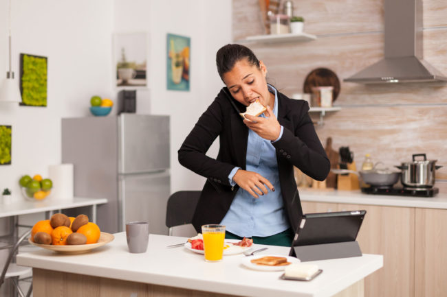 Woman eating breakfast in a hurry. 